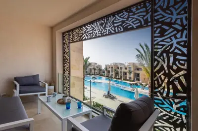 a living room with a view of a pool at Epic & Exquisite 2 BR w Beach & Pool Mangroovy in Hurghada