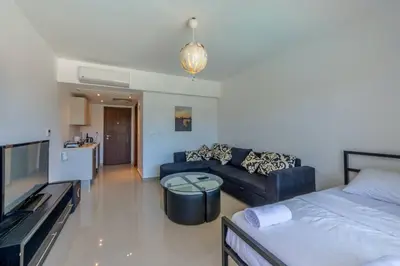 a living room with a blue couch and a tv at Cozy Studio in G-Cribs with pool - Golden Apartments El Gouna in Hurghada