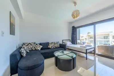 a living room with a blue couch and a table at Cozy Studio in G-Cribs with pool - Golden Apartments El Gouna in Hurghada