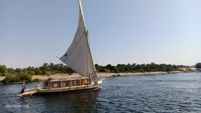 a boat with a large sail on the water at JJ Jamaica Felucca in Aswan