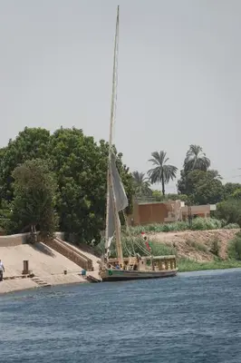 a sail boat on the water near a beach at JJ Jamaica Felucca in Aswan