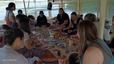 a group of people sitting around a table eating food at JJ Jamaica Felucca in Aswan