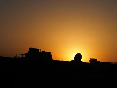 a silhouette of the sun setting in the desert at SWEET HOSTEL LUXOR in Luxor