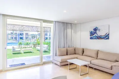 a living room with a couch and a table at Ollystays Mangroovy 2 BR Beach and Pool Free access in Hurghada