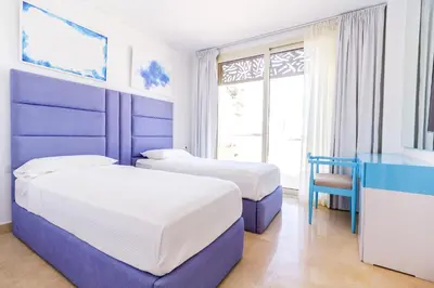 two beds in a room with blue and white at Ollystays Mangroovy 2 BR Beach and Pool Free access in Hurghada