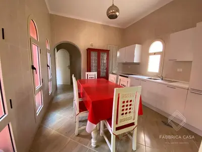 a kitchen with a red table and white chairs at FabbricaCasa Sea Front Villa, Oriental Coast in Marsa Alam City