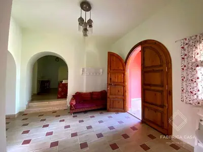 a room with two wooden doors and a red couch at FabbricaCasa Sea Front Villa, Oriental Coast in Marsa Alam City