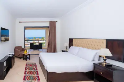 a hotel room with a bed and a balcony at New Eagles Aqua Park Resort in Hurghada