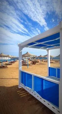 a view of a beach with umbrellas and the ocean at New Eagles Aqua Park Resort in Hurghada