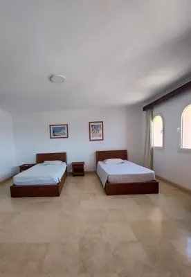 two beds in a large room with two windows at Amazing 2 bedrooms' Flat Marina El-Hurghadah in Hurghada