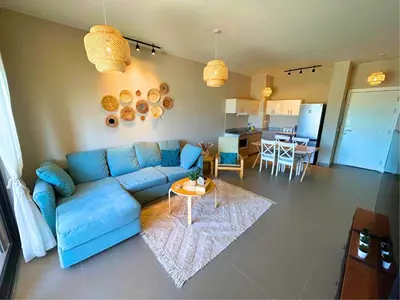 a living room with a blue couch and a table at Boho Chic - Scenic Lagoon View at Tawila, Gouna in Hurghada