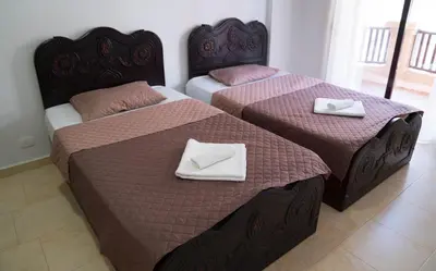 two beds in a hotel room with towels on them at Turtles Beach Resort - Sea View in Hurghada