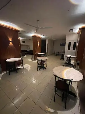 an empty room with tables and chairs and a ceiling at Grand Hotel Qena in Qena