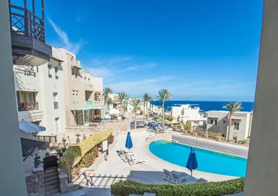 a view of the pool and the ocean from the balcony of a hotel at OSKENA Azzurra Sahl Hasheesh Hurghada in Hurghada