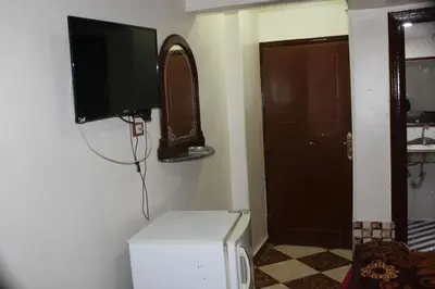 a small room with a television and a refrigerator at Tiba Hotel in Aswan