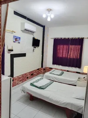 two twin beds in a room with a window at Four Seasons Hotel in Hurghada