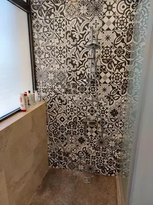a shower with a black and white patterned wall at El Gouna luxe in Hurghada