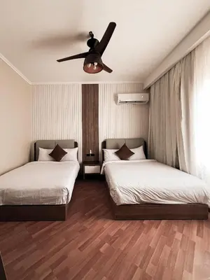 two beds in a room with a ceiling fan at GS 18 Villa in Hurghada