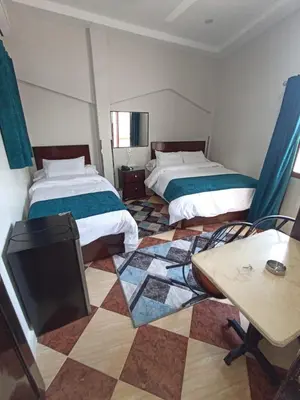 a room with two beds and a table in it at Dream Hotel in Qena
