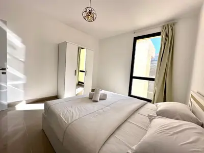 a white bedroom with a bed and a window at G cribs 2 BR sharing Pool in Hurghada