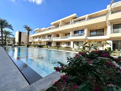 a swimming pool in front of a building at G cribs 2 BR sharing Pool in Hurghada