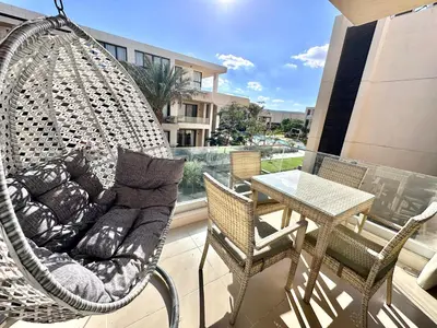 a hanging hammock on a balcony with a table at G cribs 2 BR sharing Pool in Hurghada