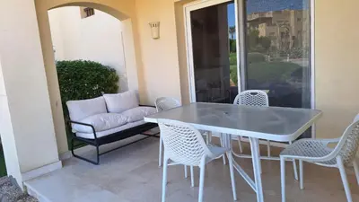 a table and chairs on a patio with a couch at Waterside Apartments, El Gouna - 1Bd Ground Floor in El Gouna