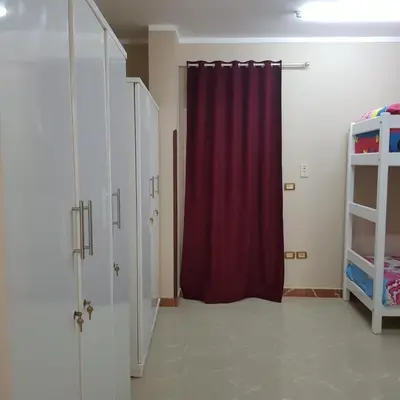 a room with a red curtain and a shelf at Sweet Home Hostel- ممنوع للمصريين open 24 hour in Hurghada