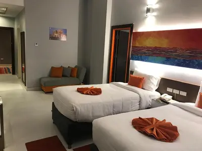 a hotel room with two beds and a couch at Gloria Aqua Park Hotel in Aswan