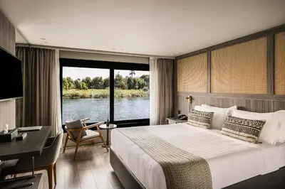 a bedroom with a large bed and a large window at Historia The Boutique Hotel Nile Cruise - Every Monday from Luxor for 04 & 07 Nights - Every Friday From Aswan for 03 & 07 Nights in Luxor