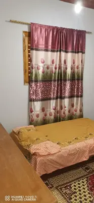a bedroom with two beds and a curtain at Tut flat in Luxor