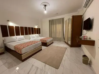 a hotel room with two beds and a television at Kemet Apartment luxor in Luxor