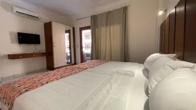 a large white bed in a room with a television at Kemet Apartment luxor in Luxor