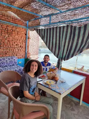 a man and a woman sitting at a table at Jamaica Guest House in Aswan