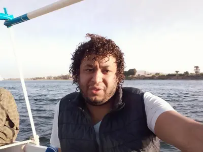 a man on a boat in the water at Nile queen Apartments for Rent in Luxor