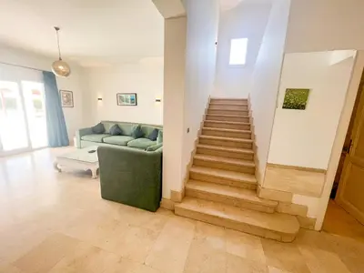 a living room with a staircase and a couch at Luxury 4 bedroom villa with a heated pool in Hurghada