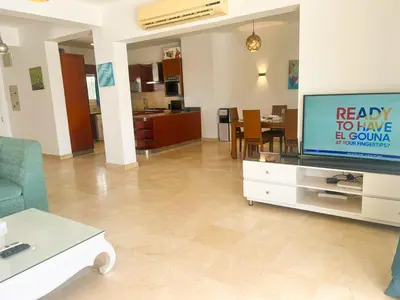 a living room with a flat screen tv and a couch at Luxury 4 bedroom villa with a heated pool in Hurghada
