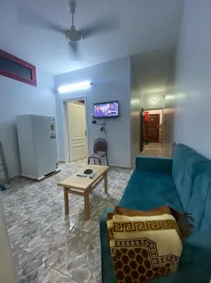 a living room with a blue couch and a table at ALRahman Building in Aswan
