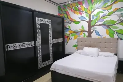 a bedroom with a white bed and a tree mural at Private House with Garden and terrace in Aswan in Aswan