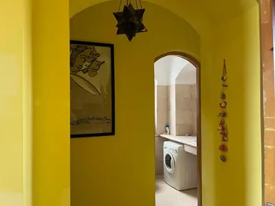 a bathroom with a yellow wall with a washing machine at El Gouna, Red Sea, Egypt, West Golf 2 Bedroom Flat in Hurghada