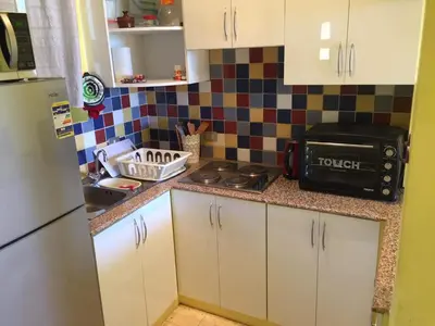 a kitchen with white cabinets and a black toaster oven at El Gouna, Red Sea, Egypt, West Golf 2 Bedroom Flat in Hurghada