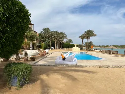 a resort swimming pool with a white couch next to it at El Gouna, Red Sea, Egypt, West Golf 2 Bedroom Flat in Hurghada