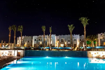 a hotel with a swimming pool at night at Sunrise Tucana Resort Grand Select in Hurghada