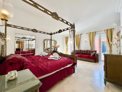 a bedroom with a large bed with a red bedspread at Hill Villa Venezia El Gouna: pool, beach & WiFi in Hurghada