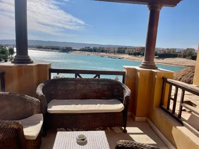 a balcony with chairs and a view of the water at Y 140 wast golf heated private pool in Hurghada