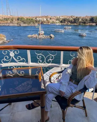 a woman sitting on a bench on a cruise ship at NUB INN in Aswan