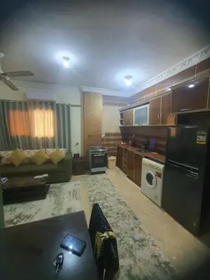 a living room with a couch and a kitchen at Abeer suites 2 in Hurghada