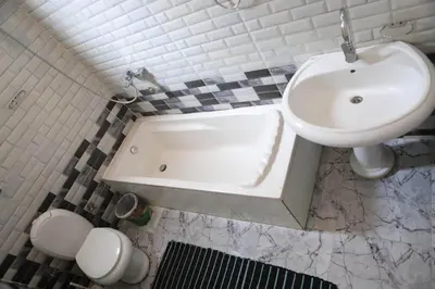 a bathroom with a sink and a tub and a toilet at Nefertarie Guest House in Luxor