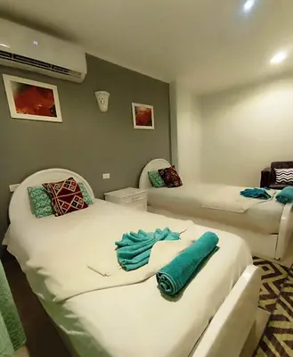 two beds in a room with blue towels on them at Nefertarie Guest House in Luxor