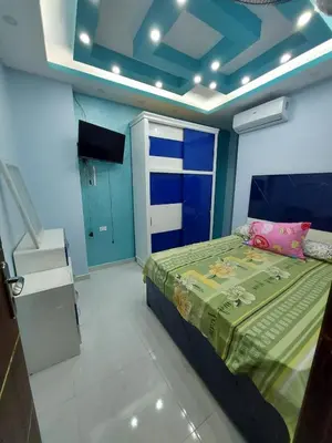 a bedroom with a bed and a blue wall at شقة فندقية على البحر in Hurghada